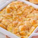 Donut bread pudding in baking dish, next to donuts.