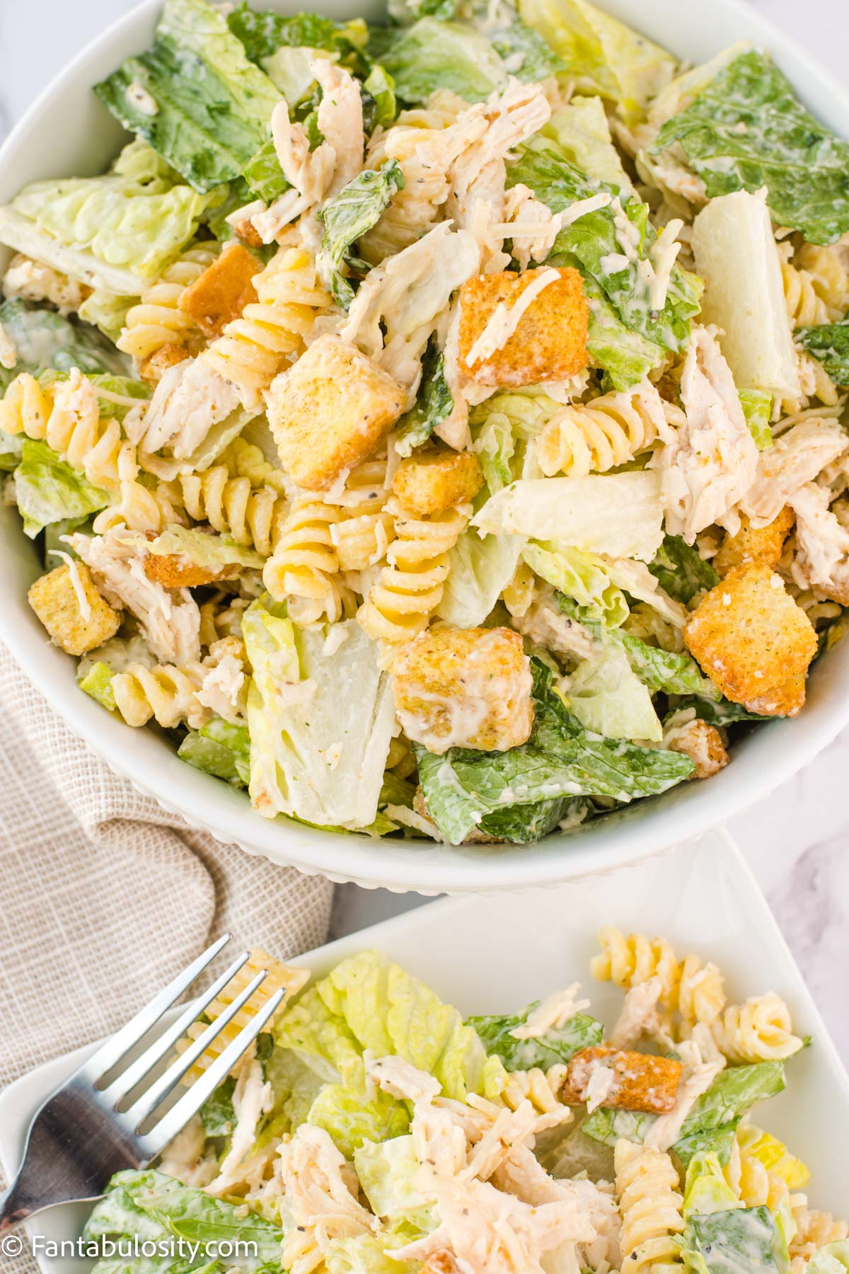 Chicken Caesar Pasta Salad Recipe in a bowl with a cloth