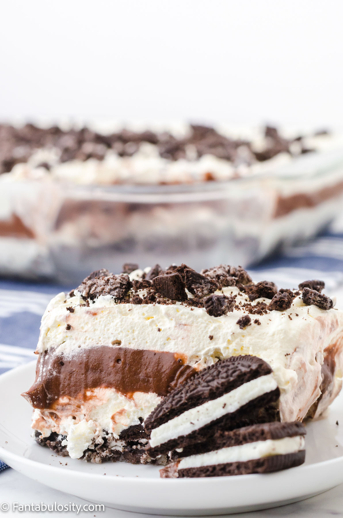 Slice of no bake Oreo dessert on a white plate with cookies