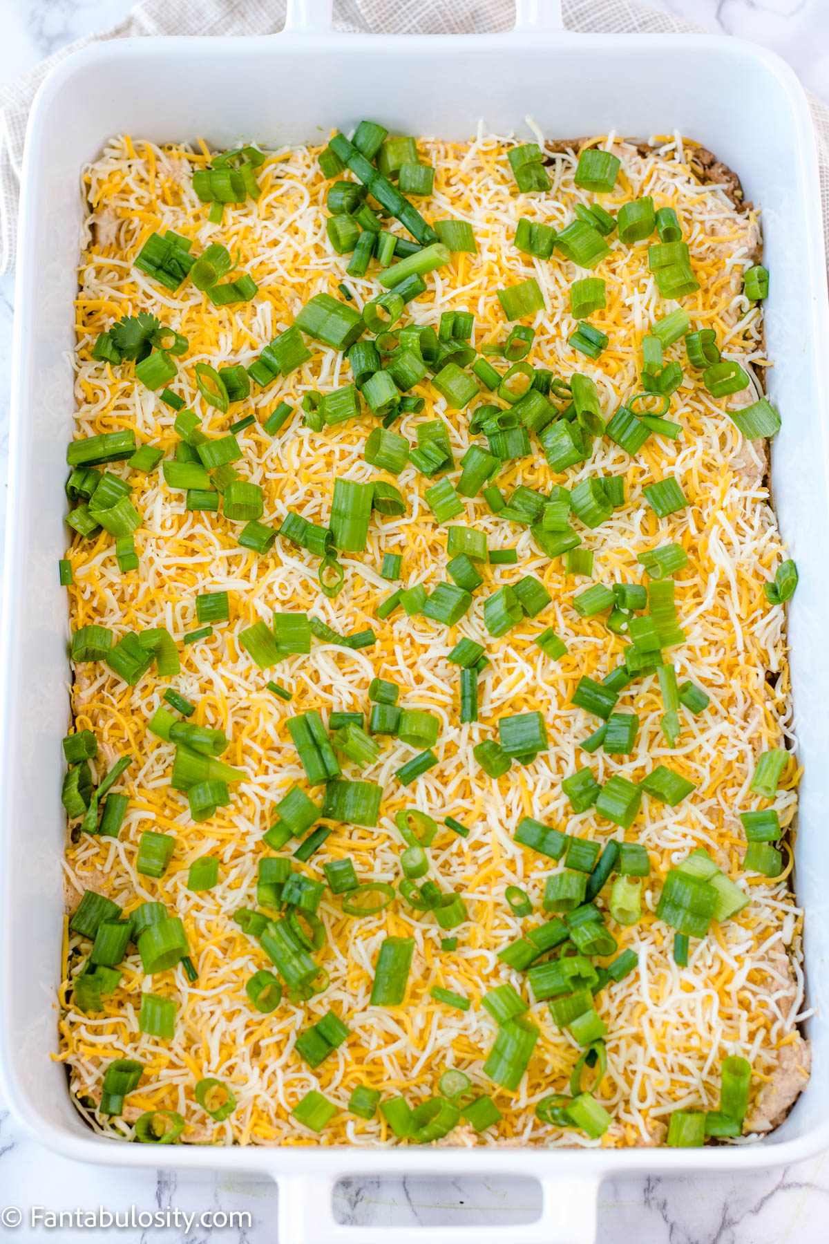 sliced green onions on top of taco layer dip