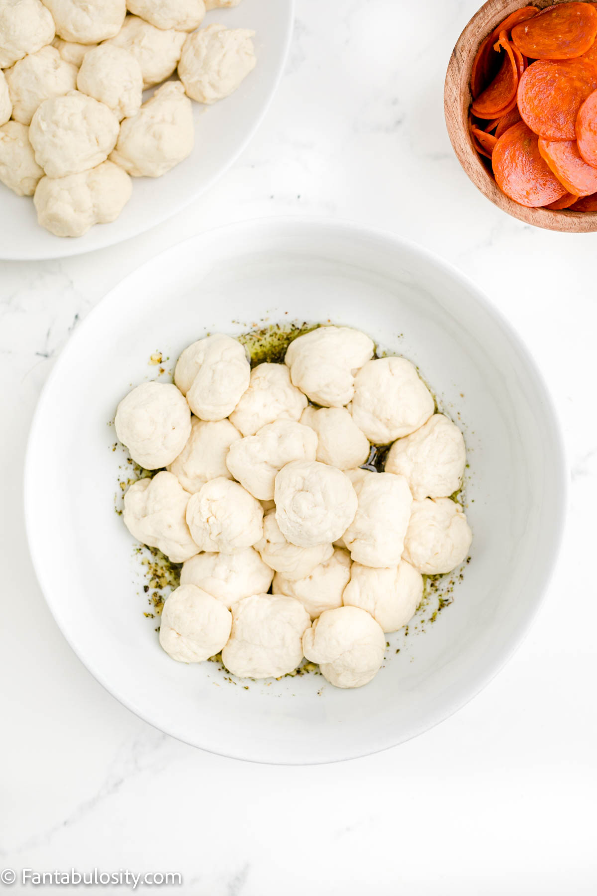 dough balls in bowl with oil and spices