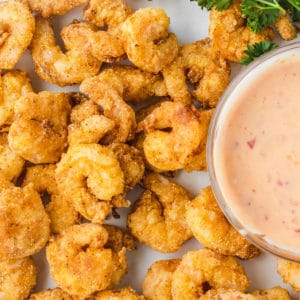 fried shrimp on plate next to sauce