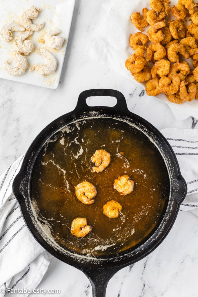 shrimp pan frying in oil and cast iron pan