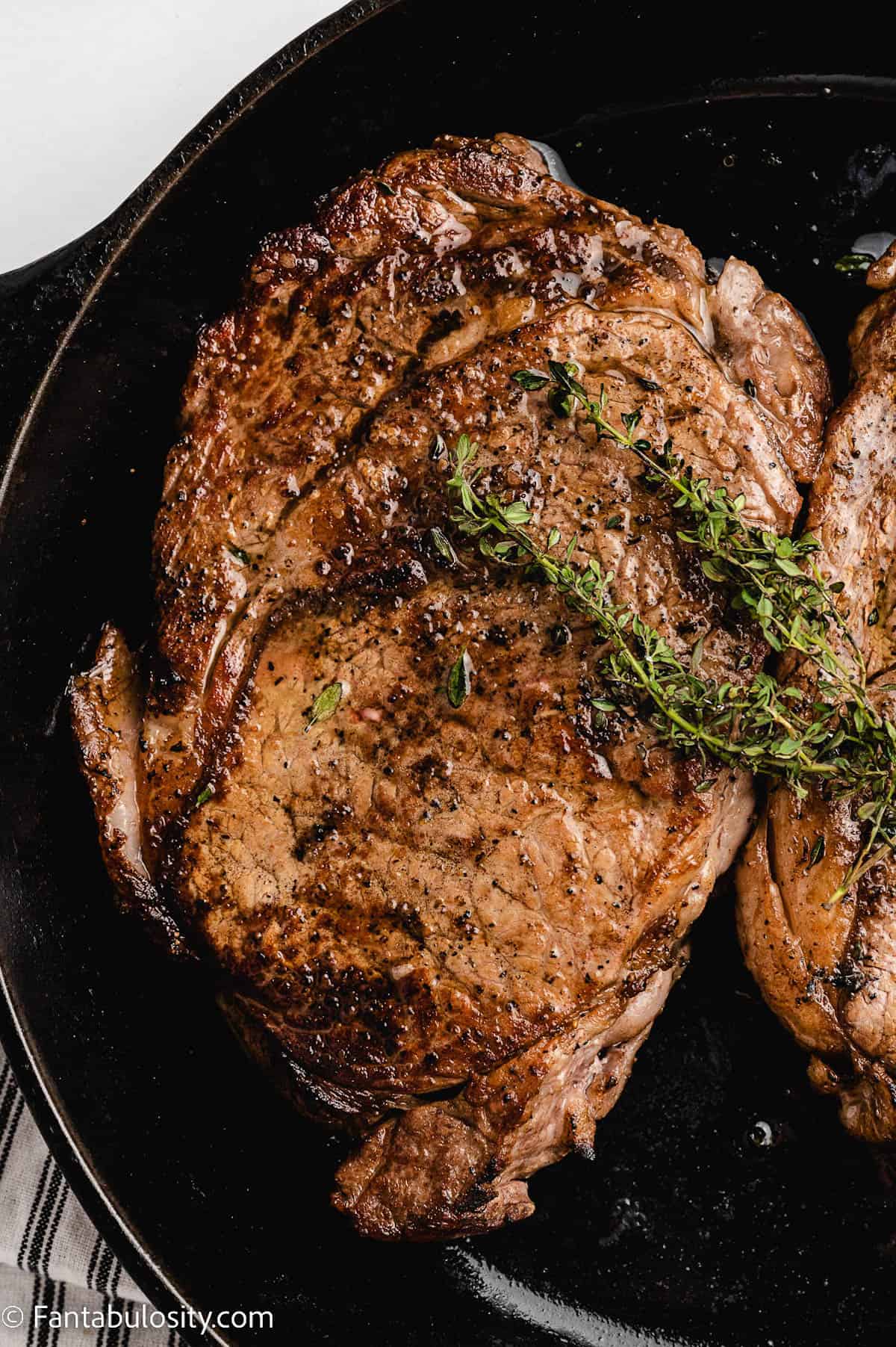 Large ribeye steaks in cast iron pan