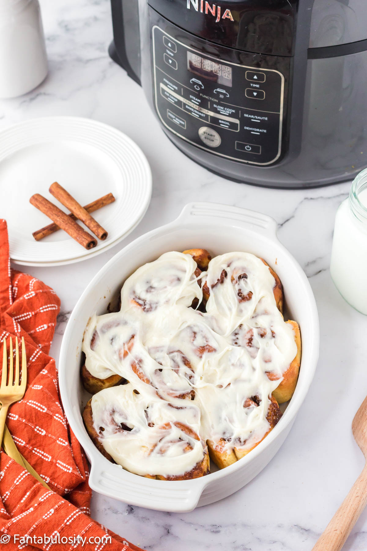 A casserole with cinnamon rolls with icing.