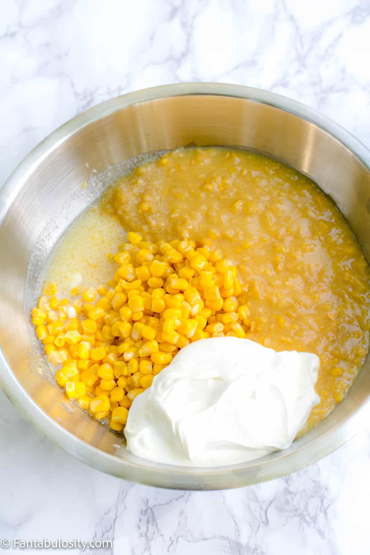 Corn, butter, sour cream in mixing bowl