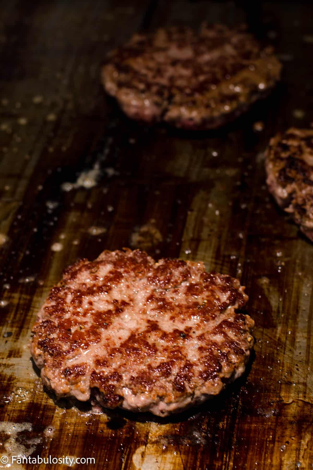 Flipped burger patties cooking