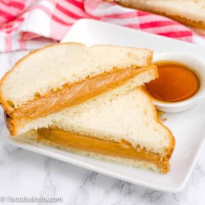 Peanut butter and syrup sandwich sliced in half, stacked on top of each other.