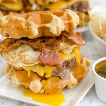 Waffle Burger on white plate with small bowl of syrup