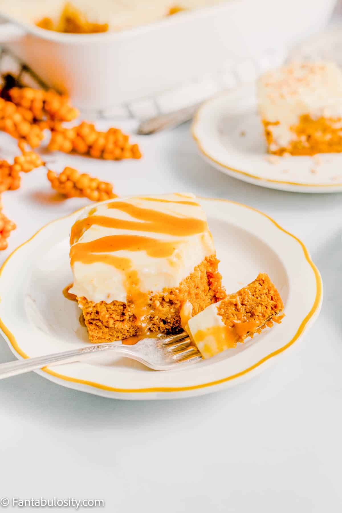 Slice of pumpkin poke cake with bite on fork