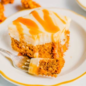 Slice of pumpkin poke cake on plate with fork