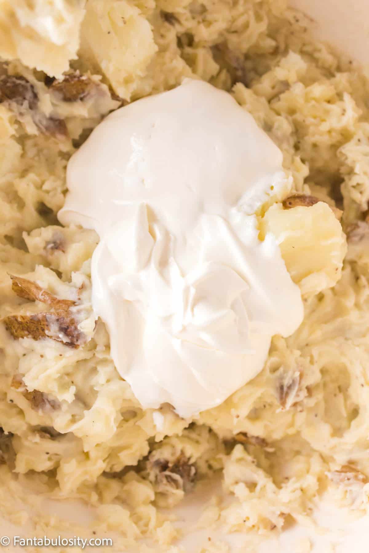 Sour cream in bowl of potatoes