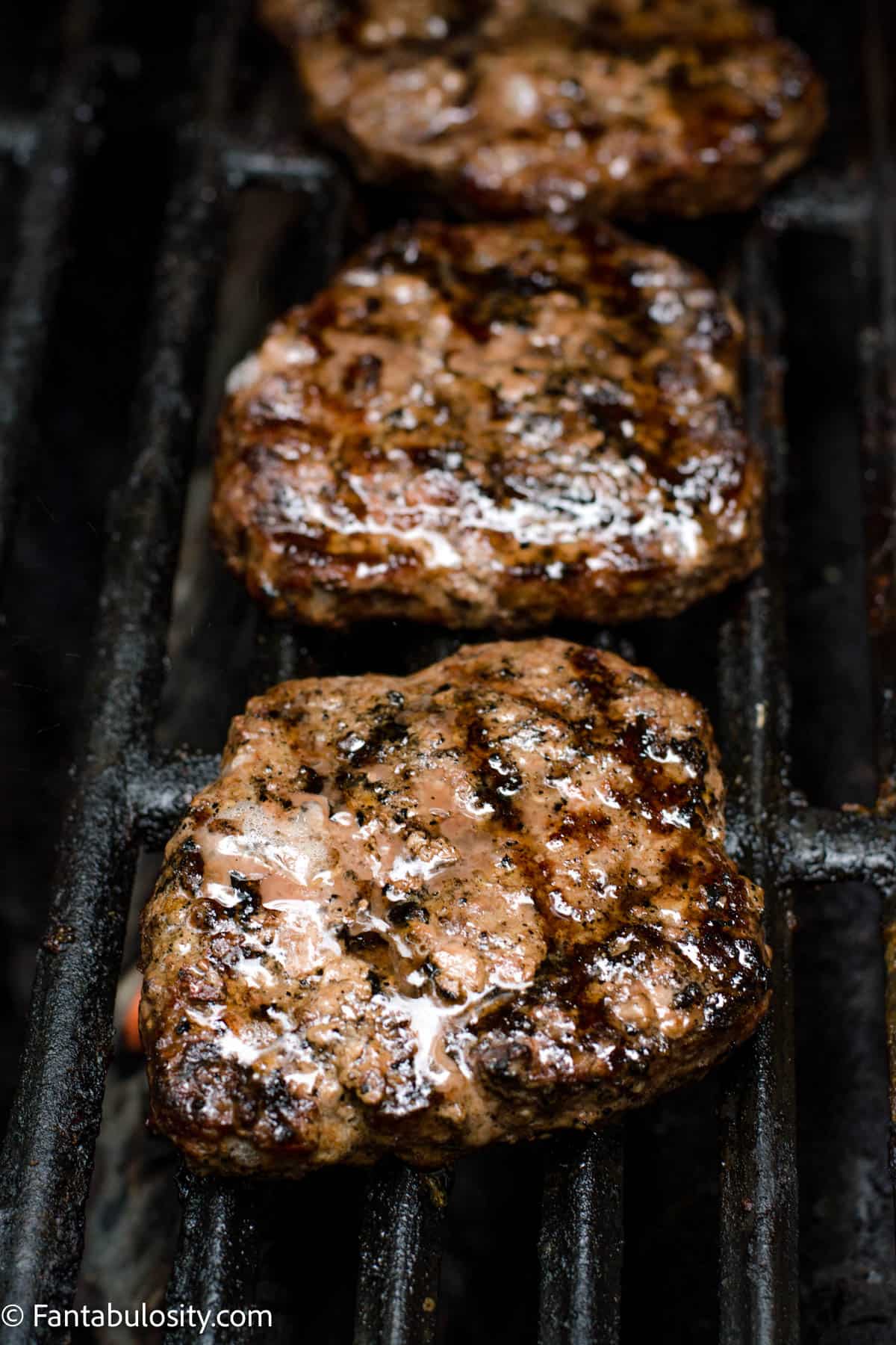 Fully cooked burger patties on grill