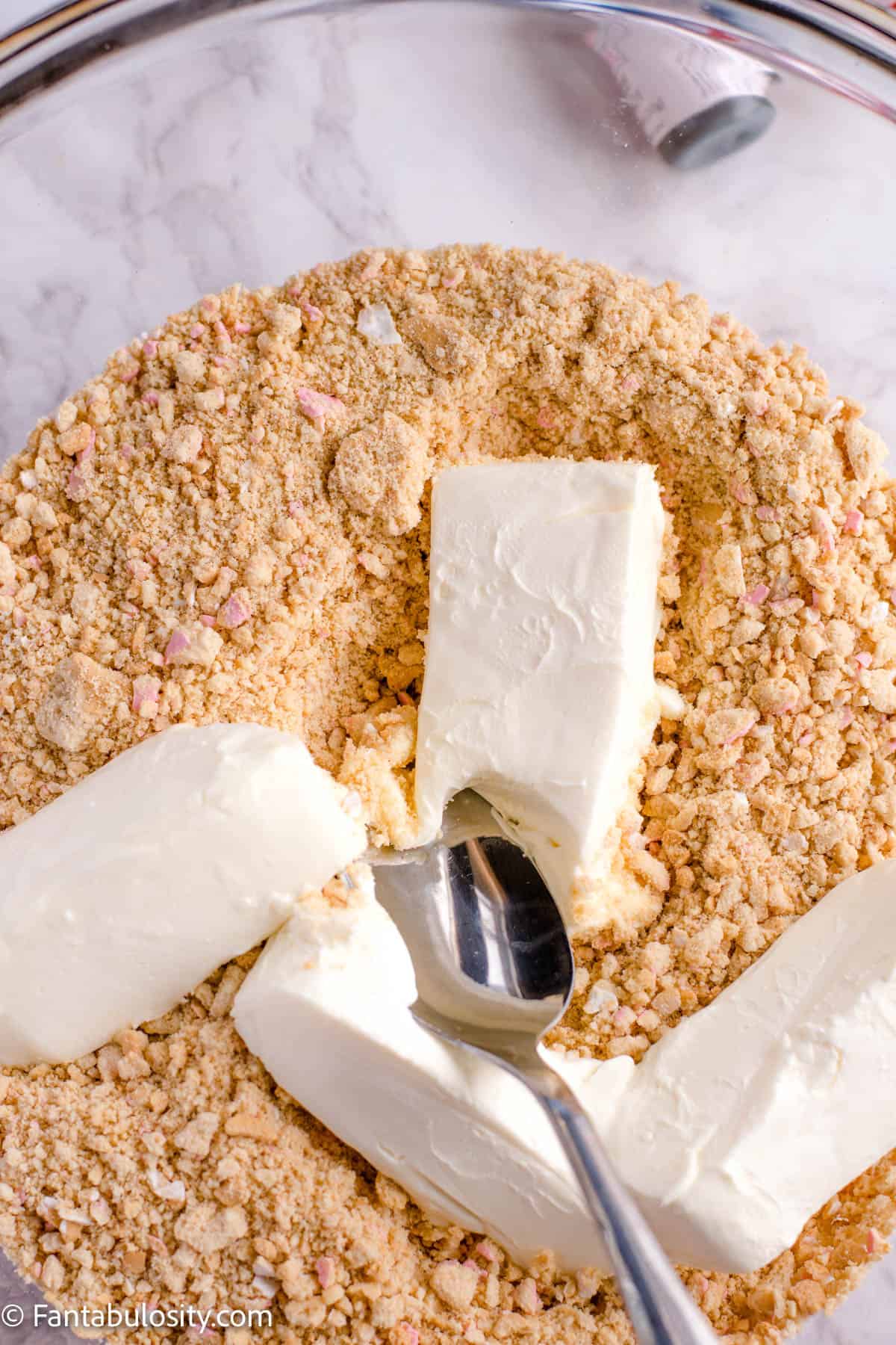 cream cheese in bowl with crushed cookies