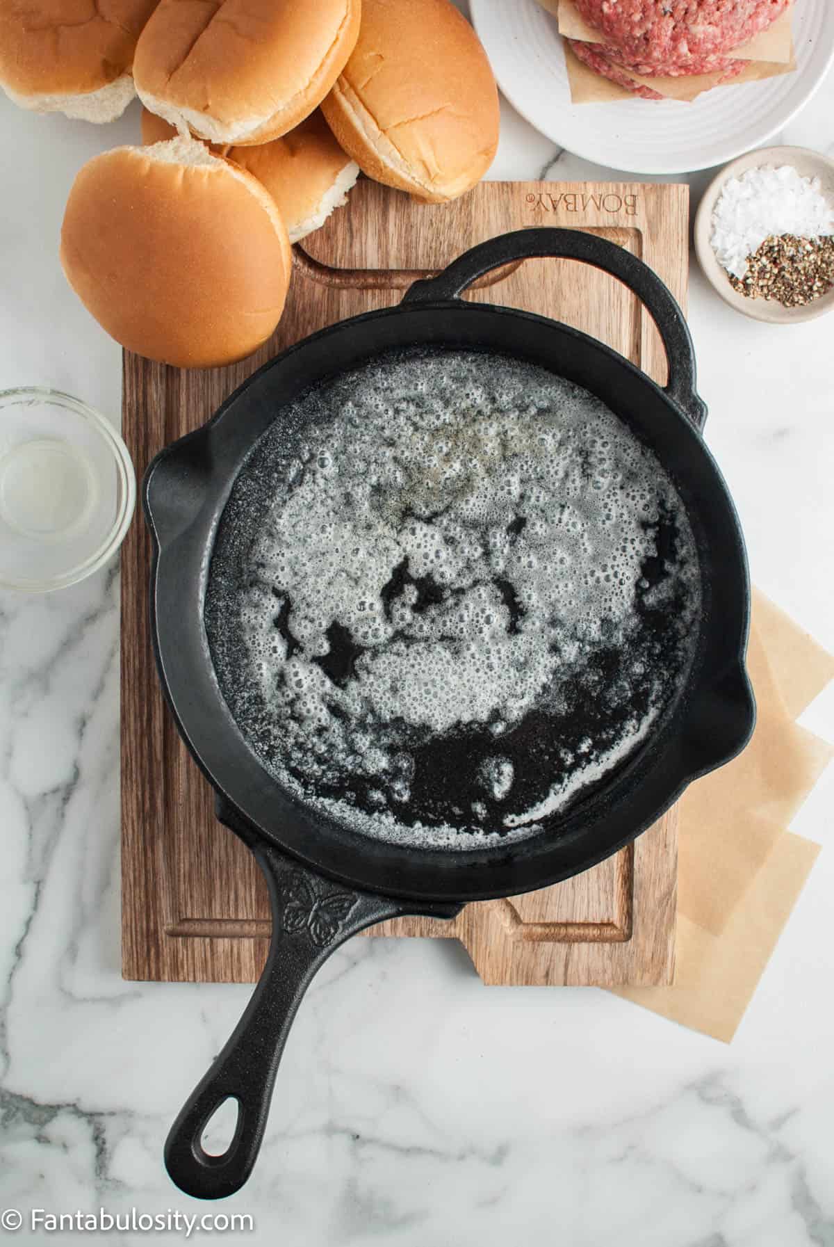 A skillet with melted butter bubbling inside of it.