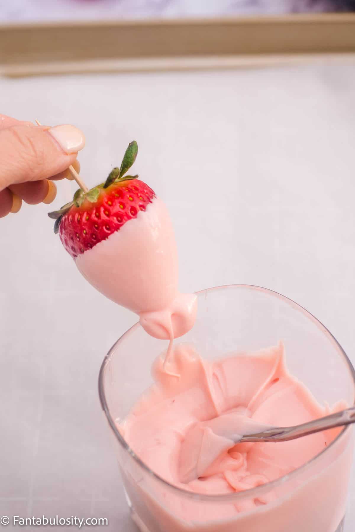 strawberry being gently pulled alongside of glass