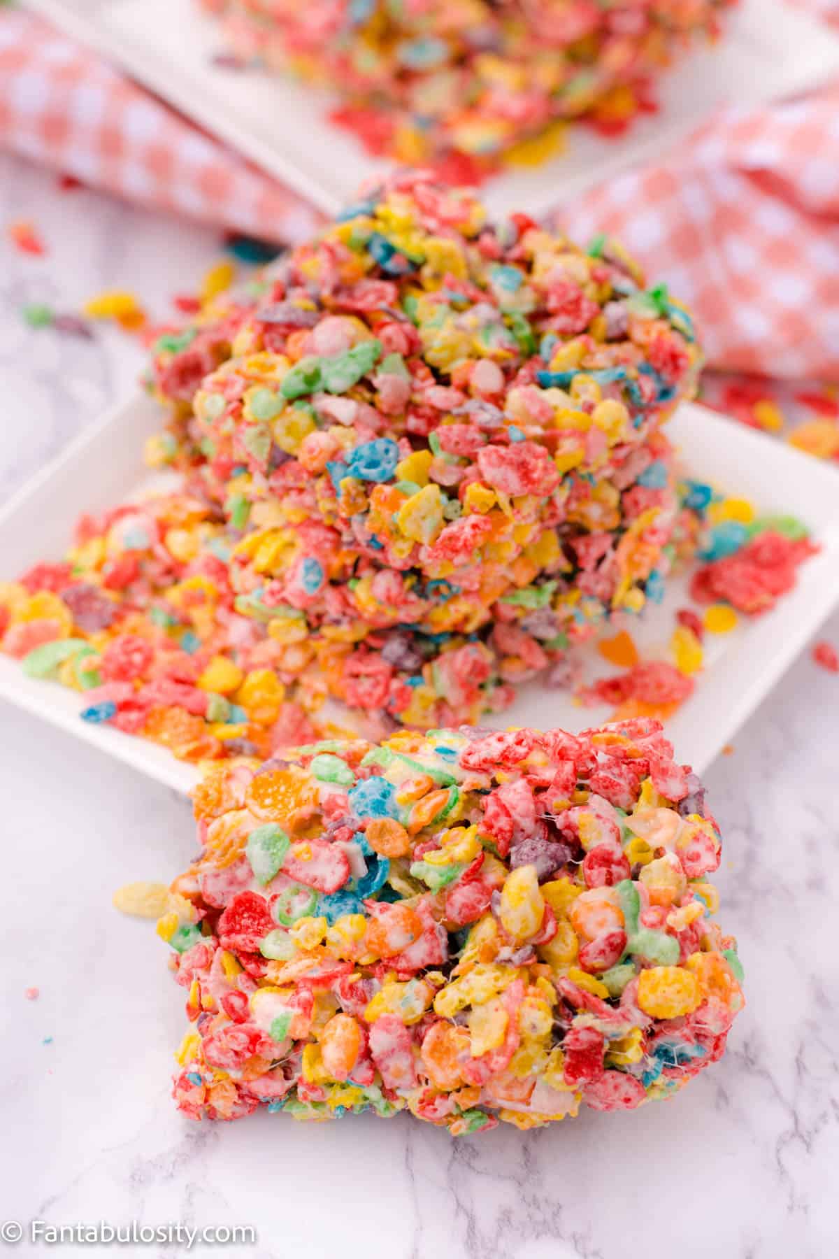 Stacked Fruity Pebble treats on white plate