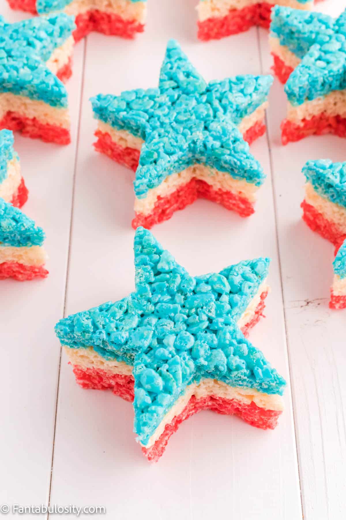 Several red, white, and blue star shaped Rice Krispie treats sitting on a counter.