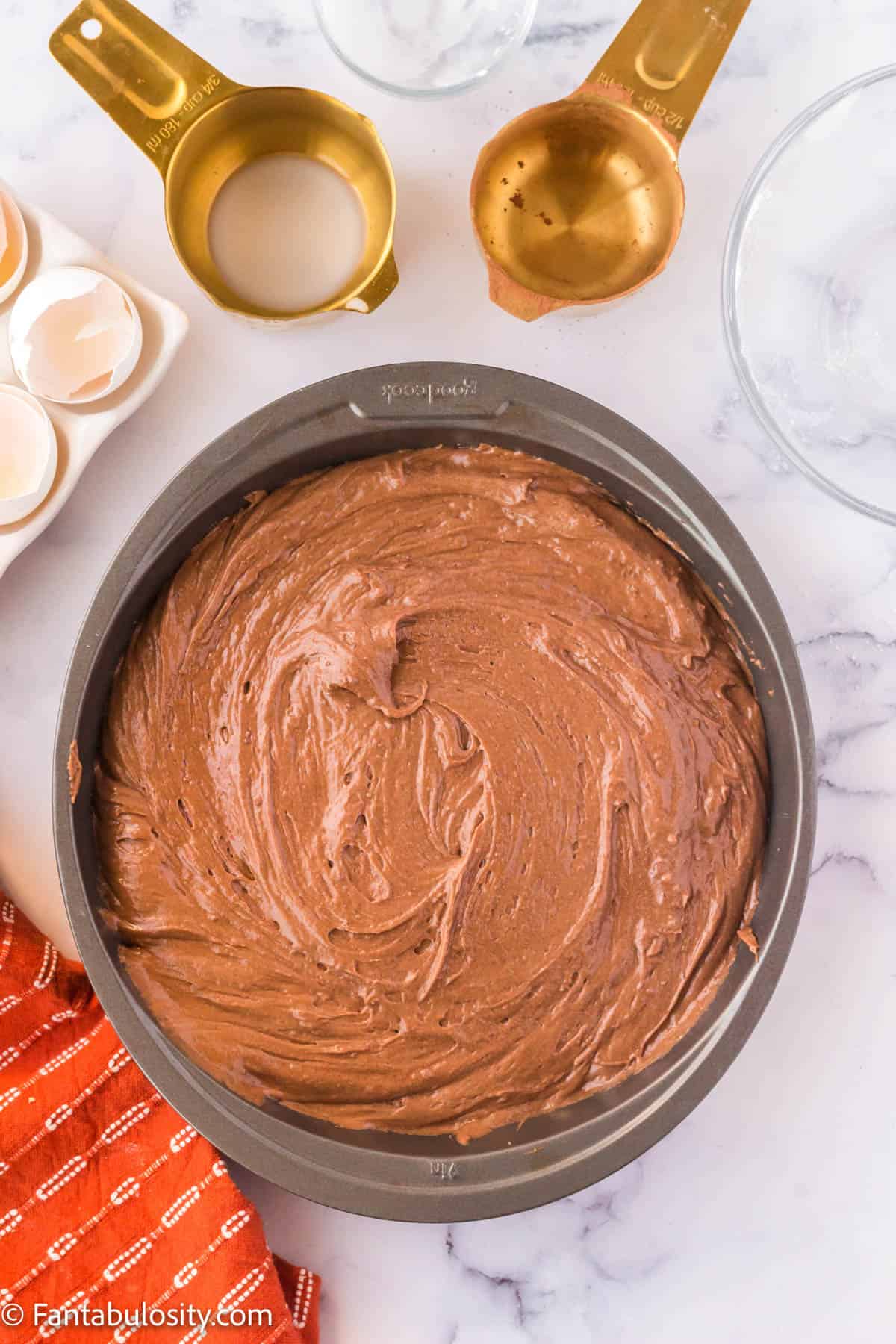 One 9-inch round cake pan with cake batter in it.