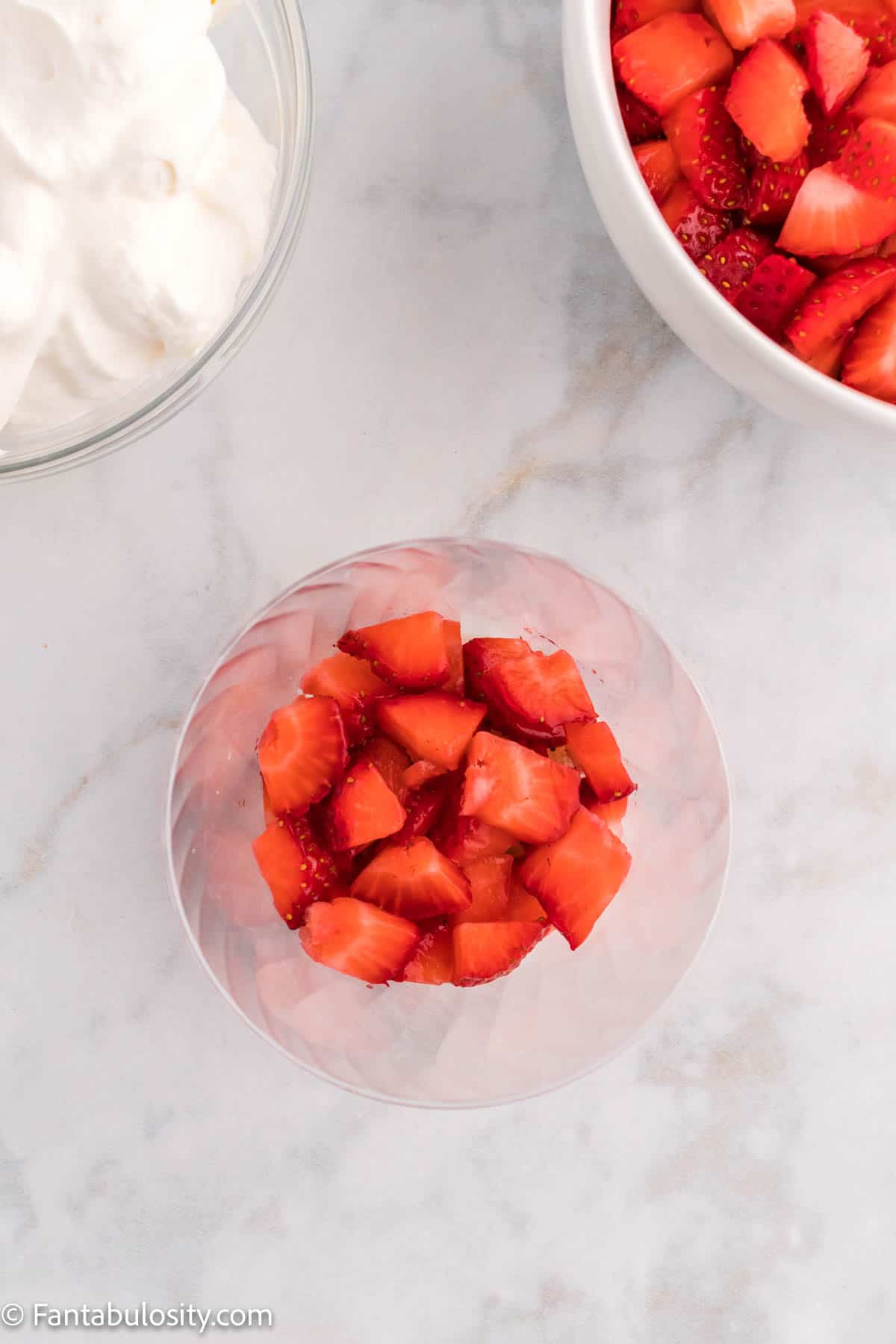 A layer of chopped strawberries in a plastic cup.