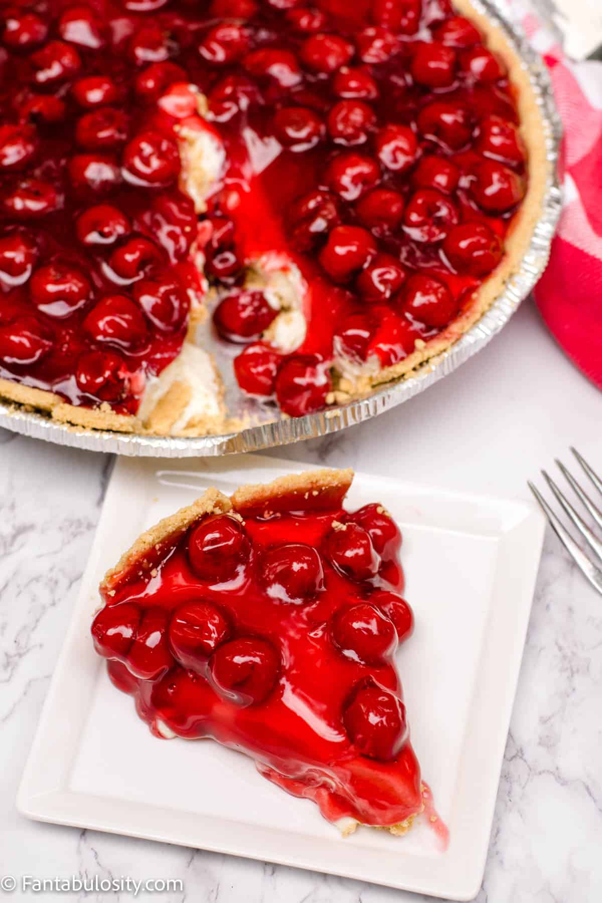 no bake cherry cheesecake with slice on plate next to it