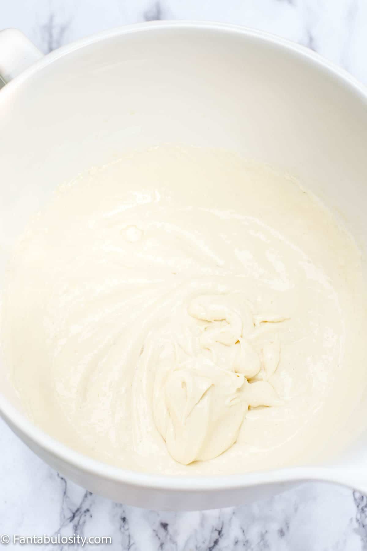 Mixed cream cheese with liquids in bowl