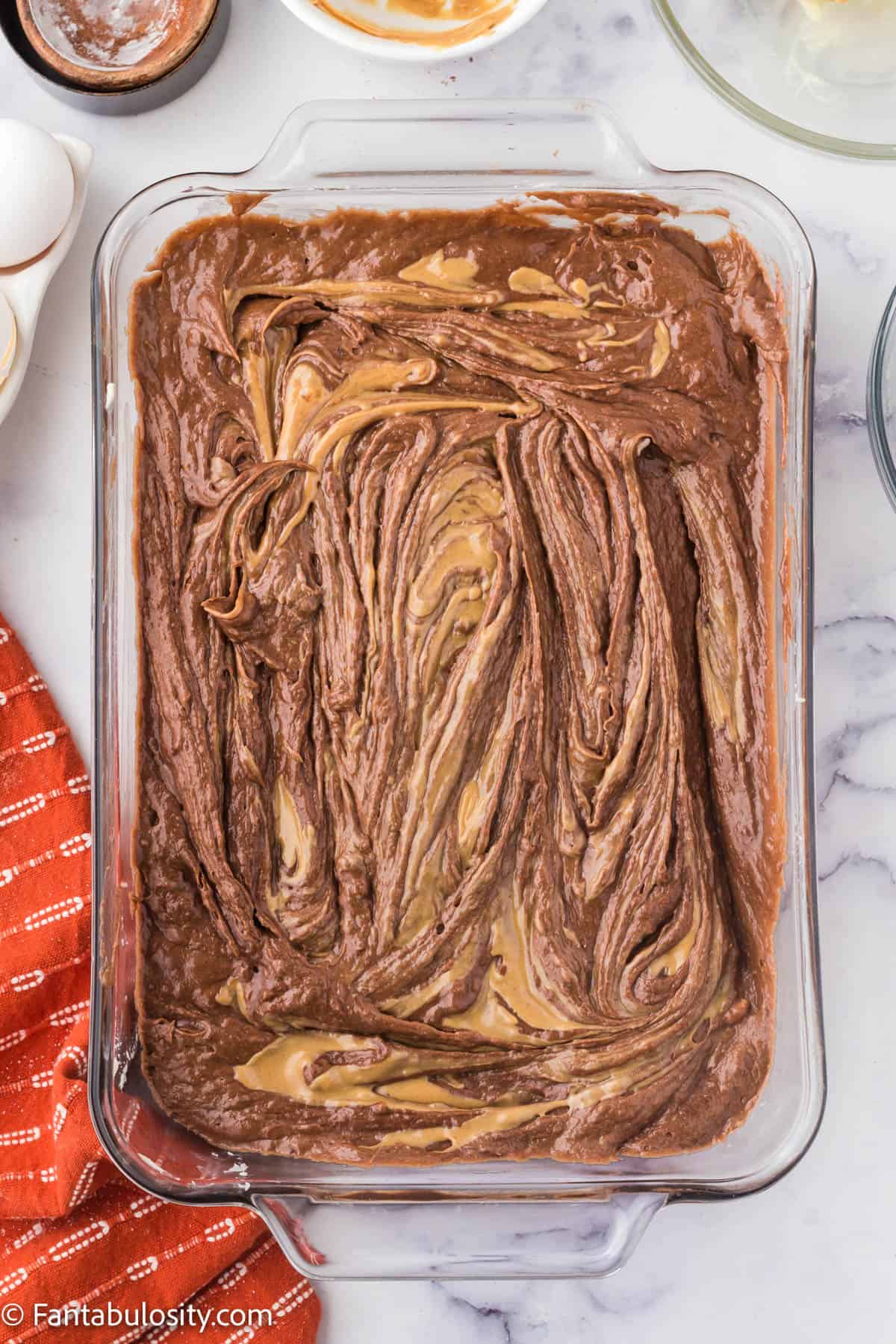 Brownie batter spread into a prepared 9x13 pan.