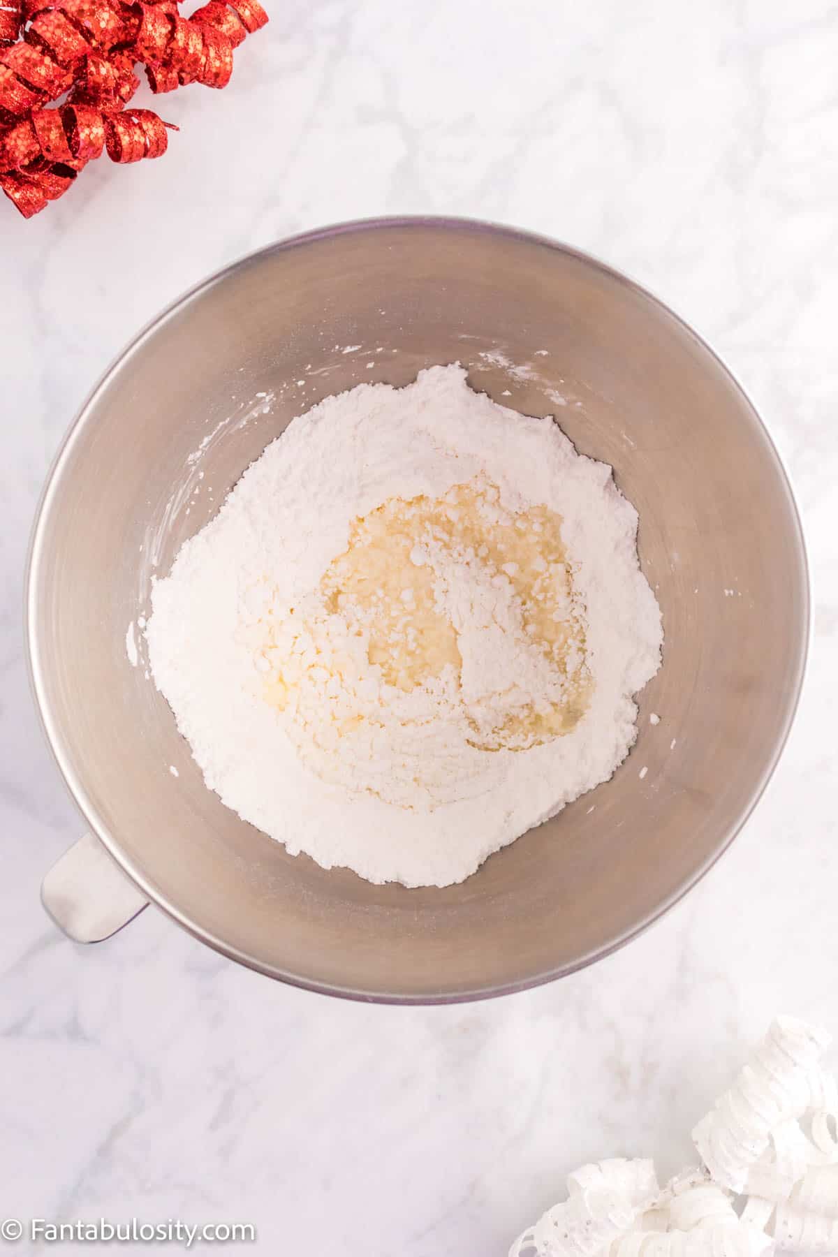 Creamed butter and powdered sugar in a mixing bowl.