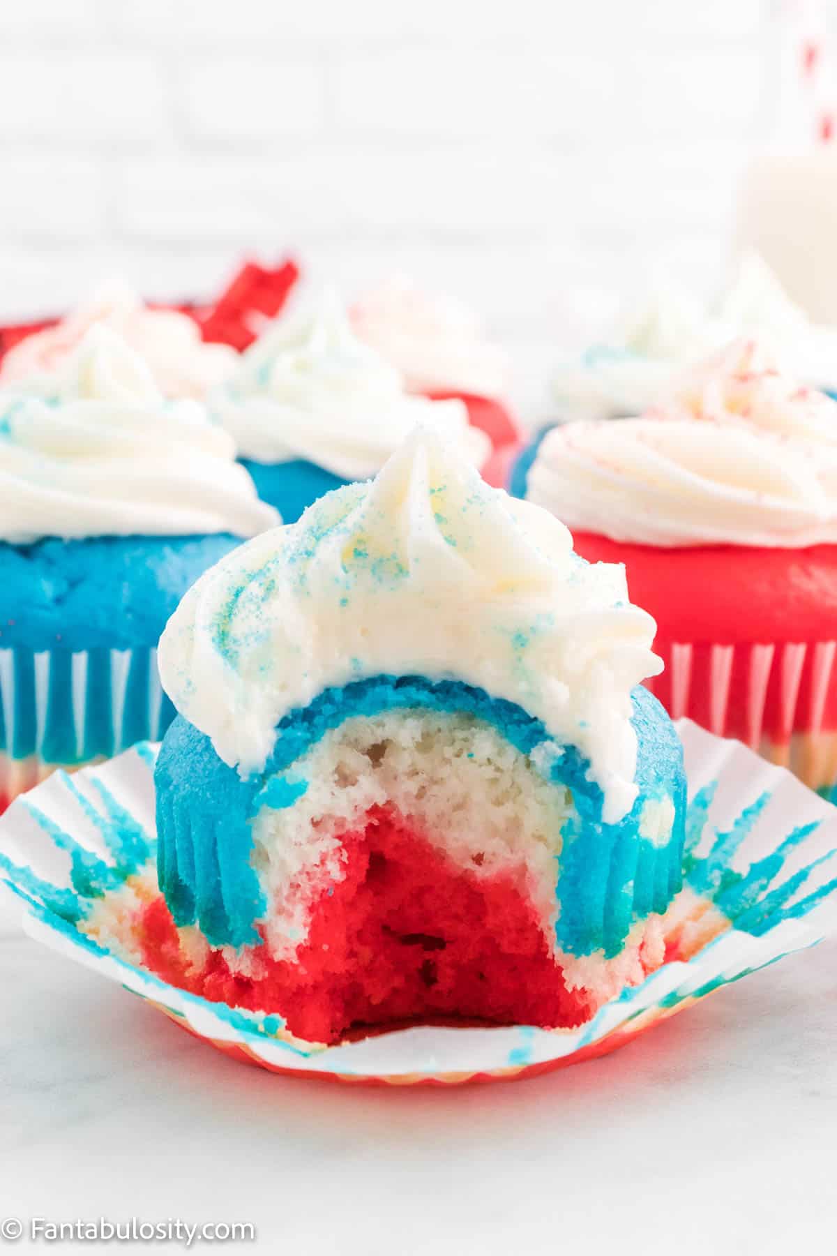 4th of July cupcakes with a bite out of the one in front. 