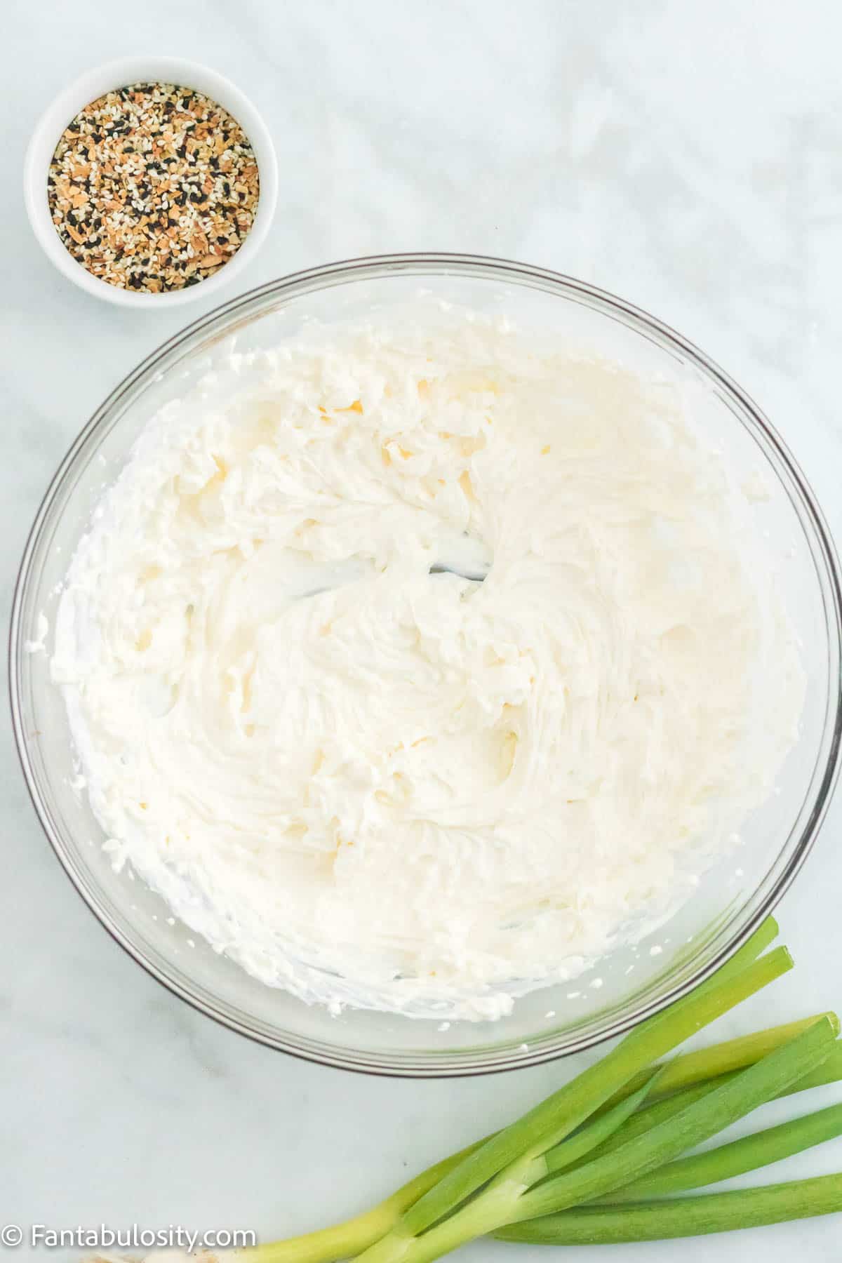 Cream cheese and sour cream blended together in a mixing bowl. 