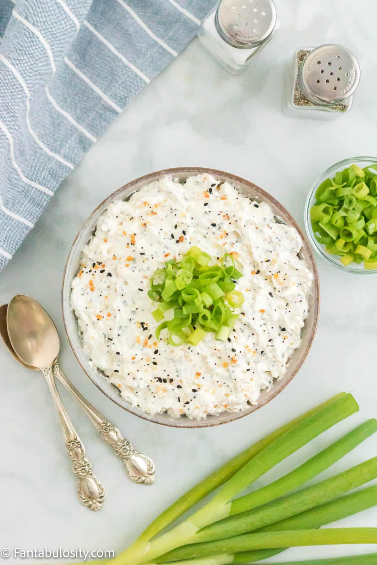 Everything but the bagel dip in a bowl with chopped scallions on top.