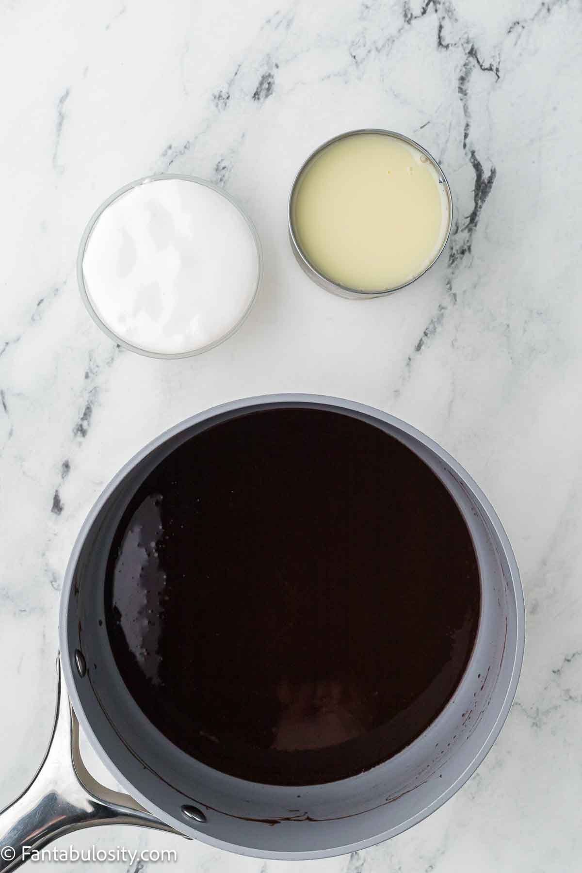 Melted chocolate mixture with sweetened condensed milk and marshmallow cream sitting next to it. 