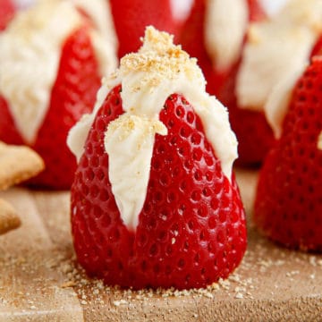 Close-up of strawberry, cut open half way from bottom, with cheesecake filling