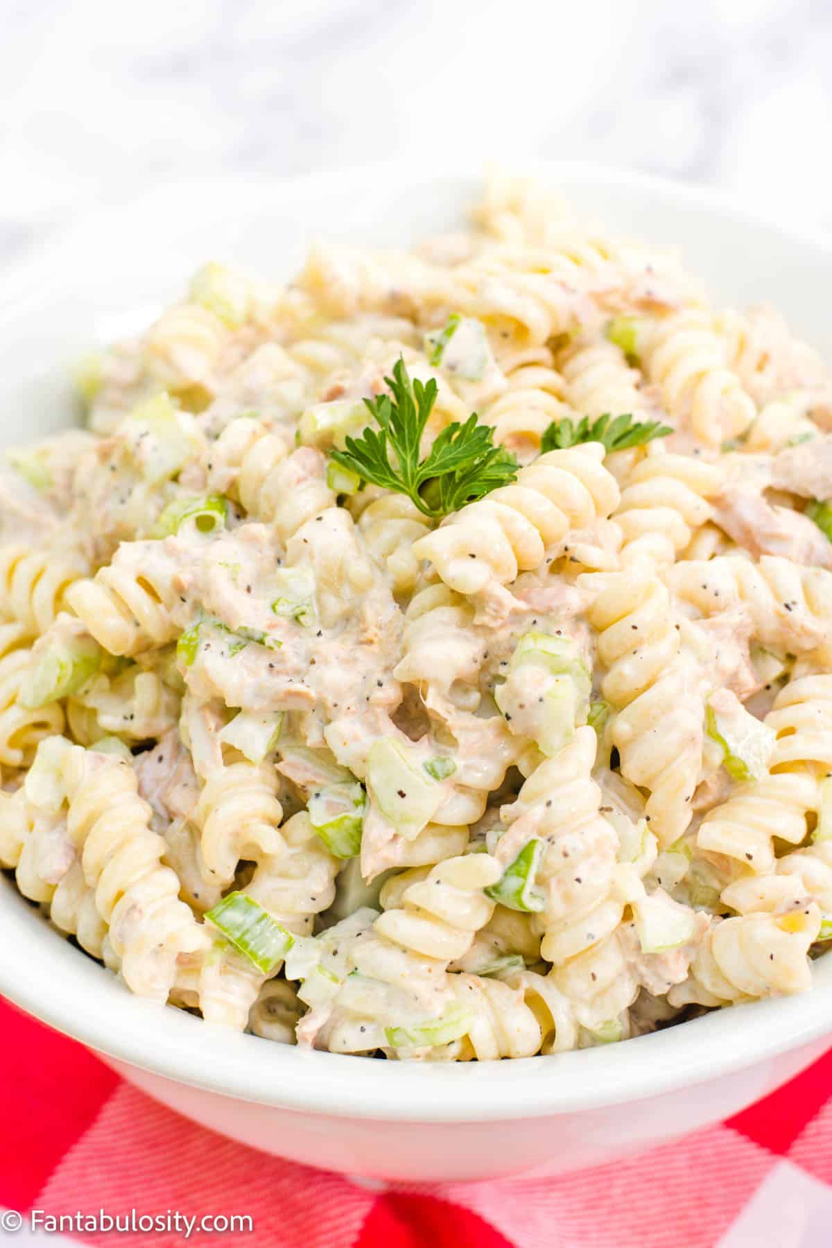 A large white bowl filled with tuna pasta salad.