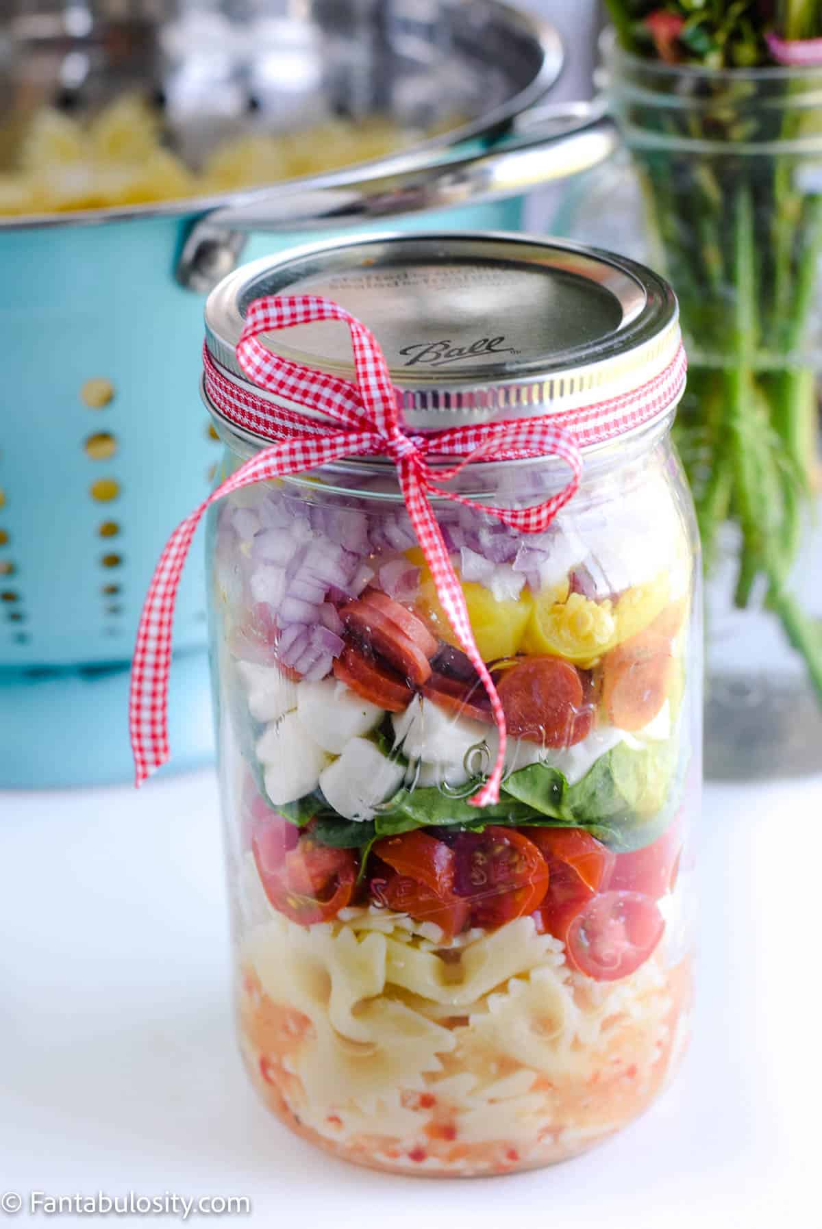 Zesty pasta salad in mason jar.