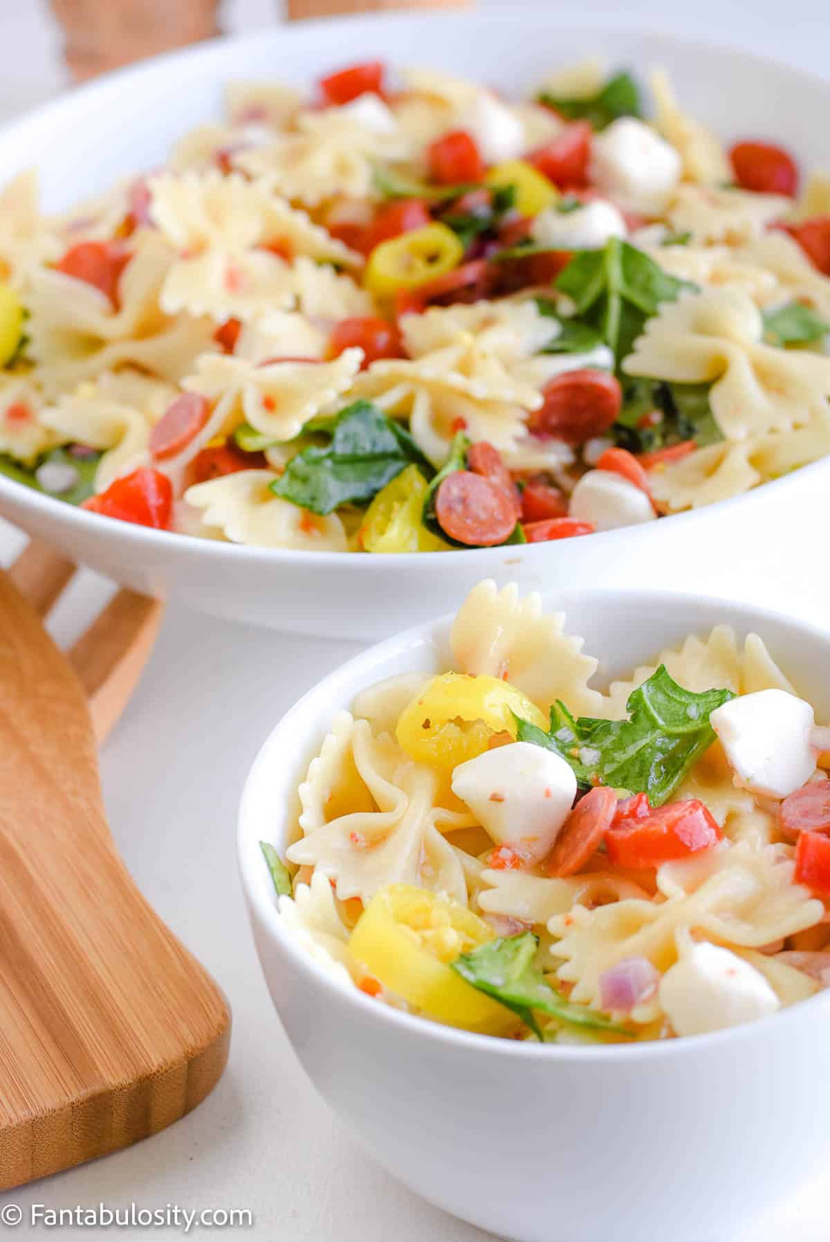 
Bowls of zesty pasta salad with tomatoes and banana peppers.	
