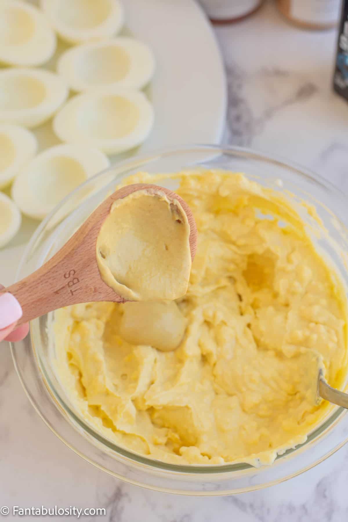 mustard being added to yolk