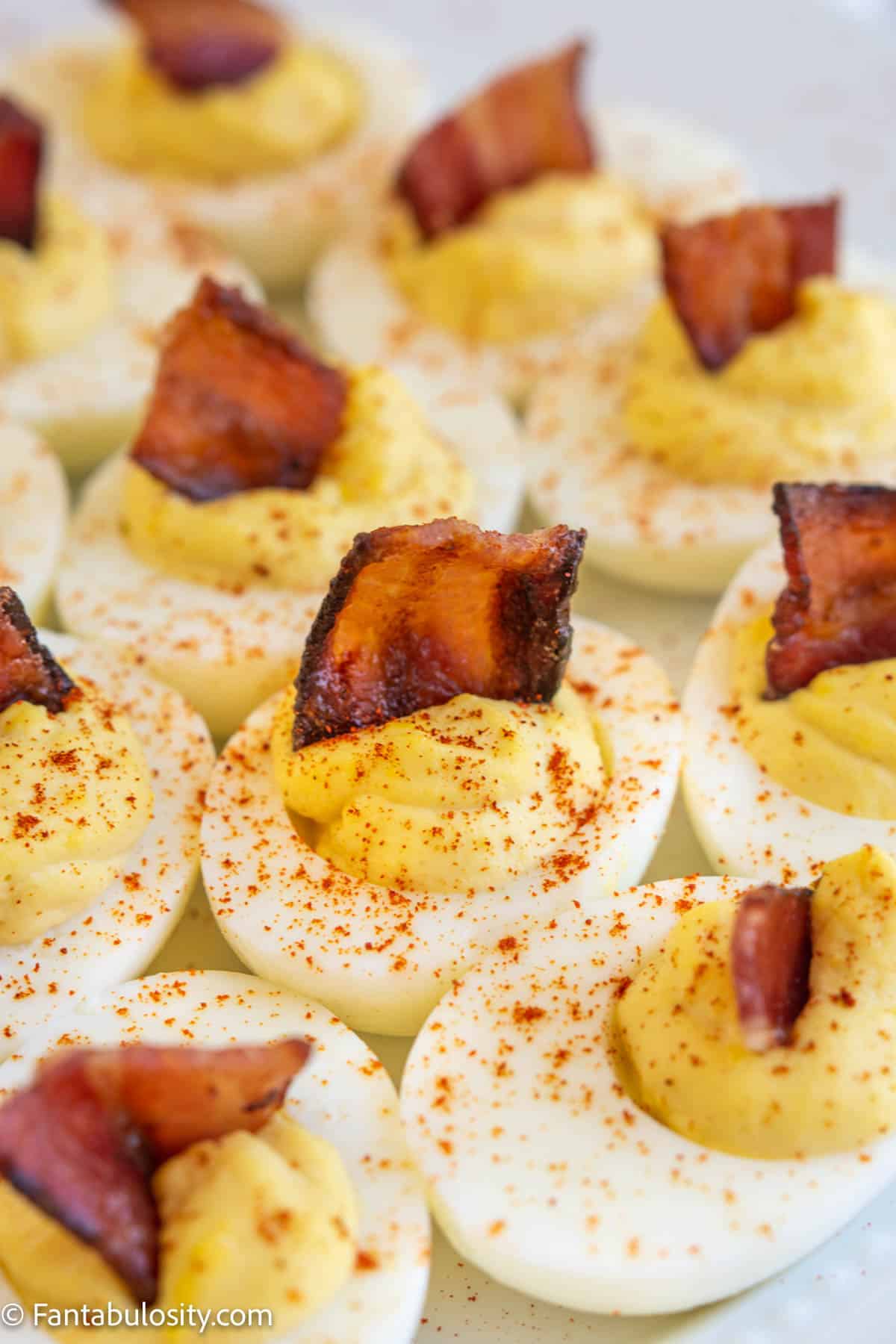Close up of deviled eggs with candied bacon