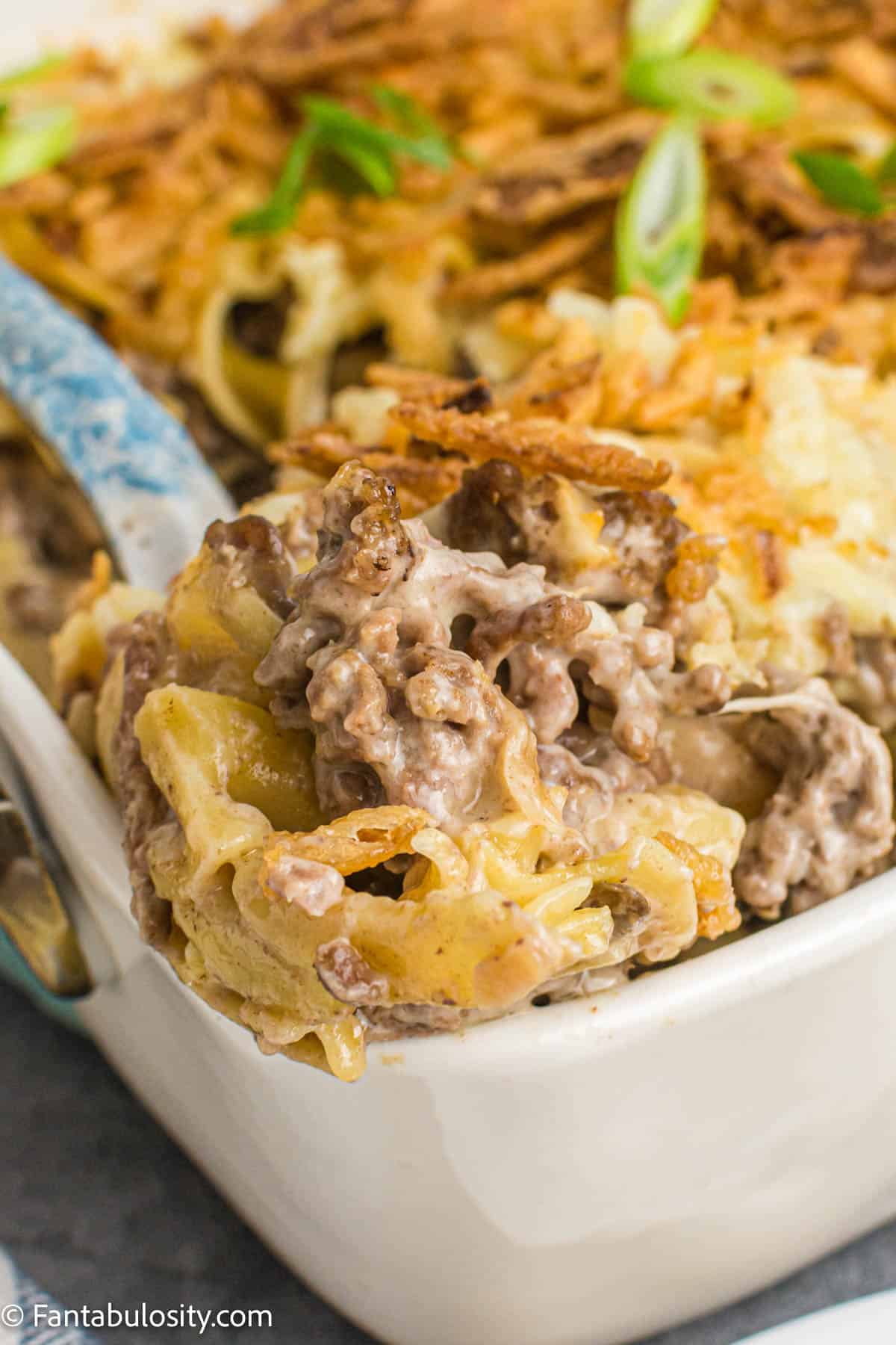 french onion beef casserole in dish with spoon lifting up serving size