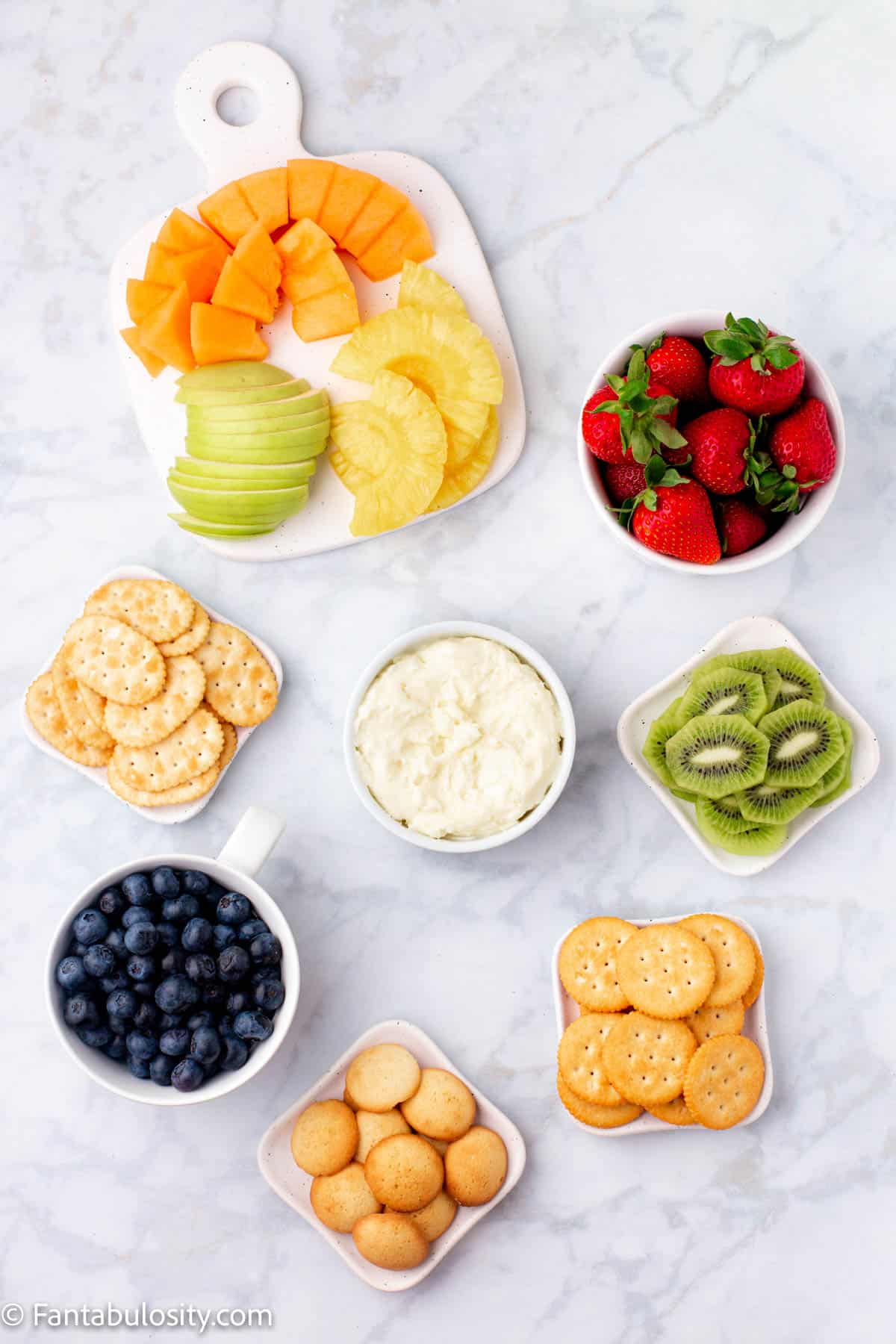 Fruit and crackers in small bowls on counter