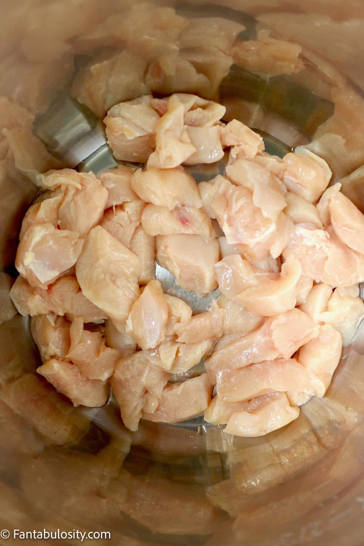Raw chicken breast pieces in an Instant Pot.
