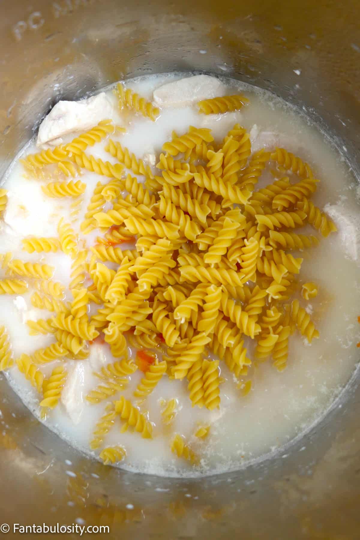 Uncooked pasta in the Instant Pot with the other ingredients.