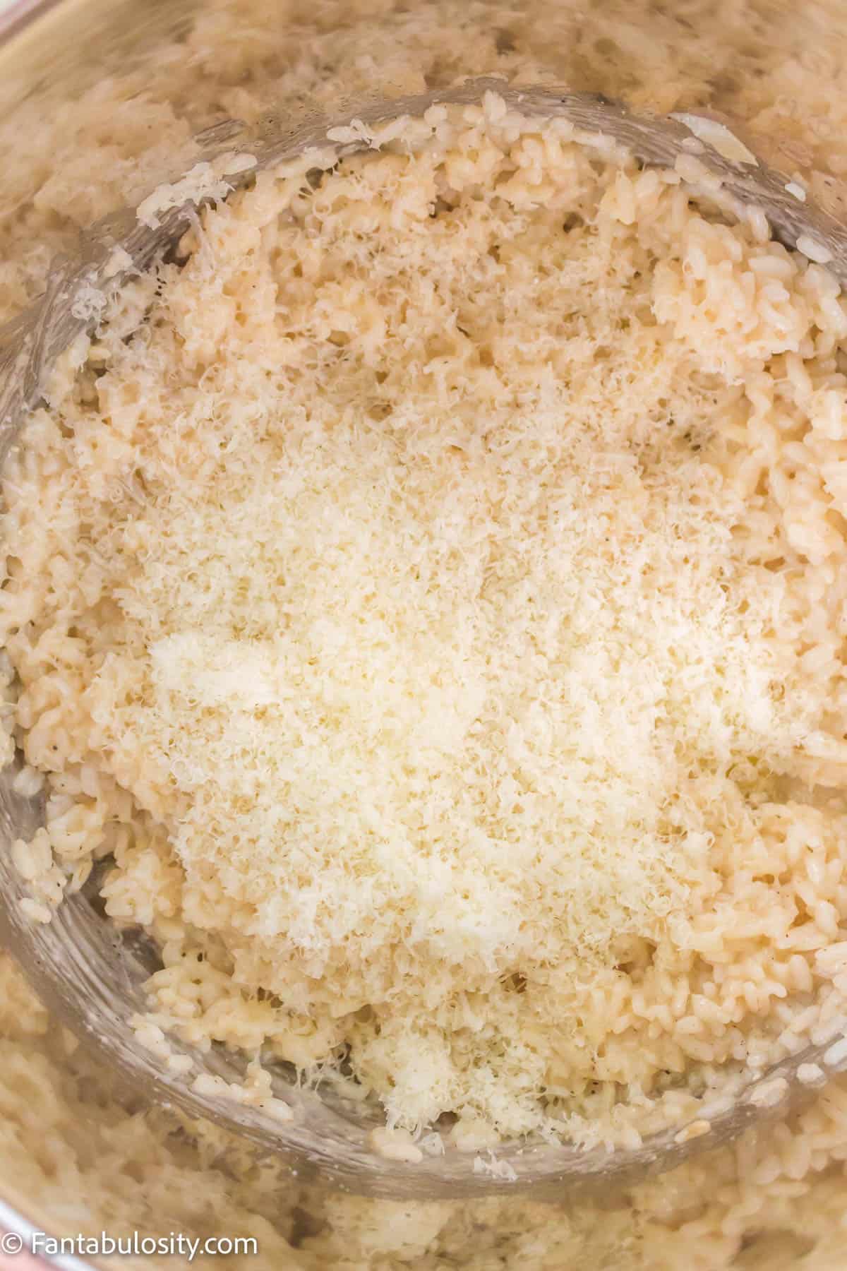Parmesan cheese sprinkled on top of the cooked rice in the Instant Pot.