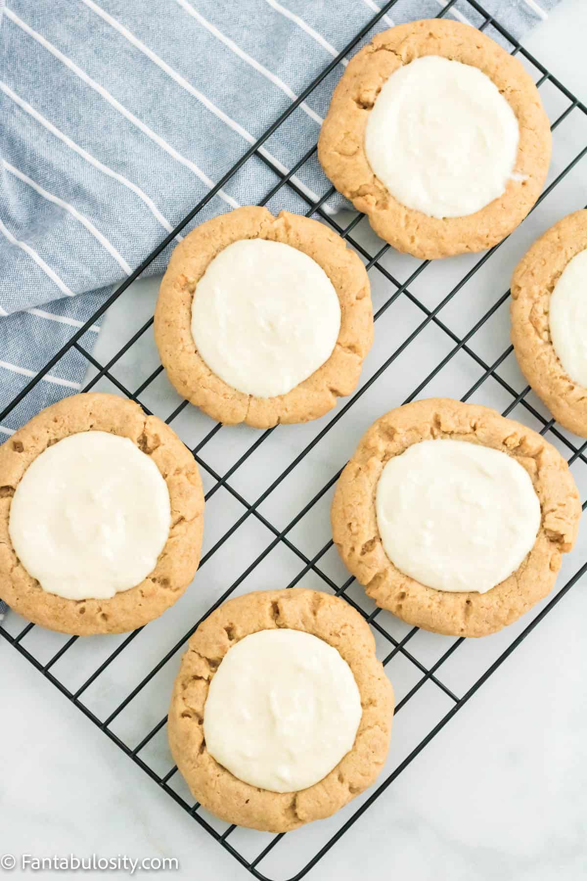 Key lime pie cookies with the filling added, sitting on a wire rack. 
