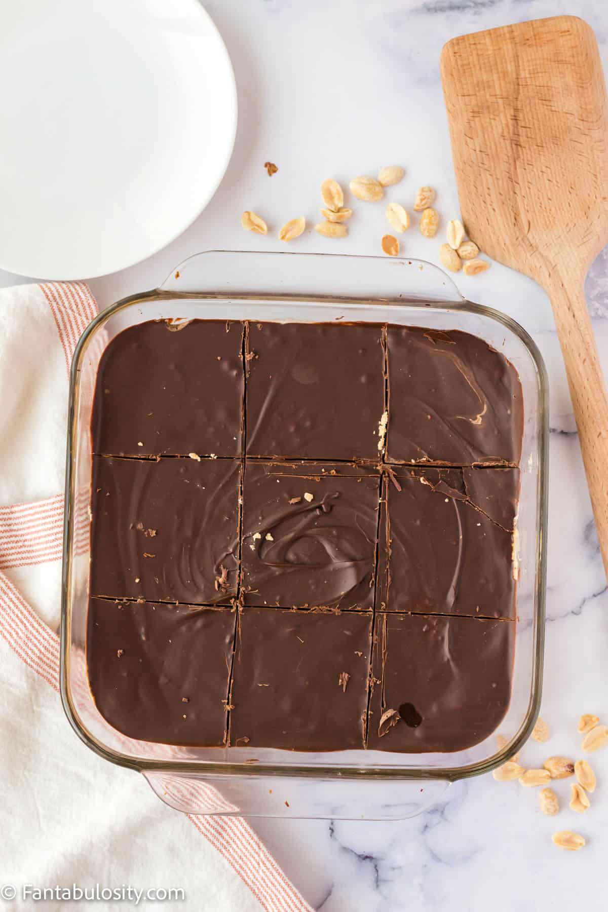 An 8x8 square pan with chocolate peanut butter bars in it.
