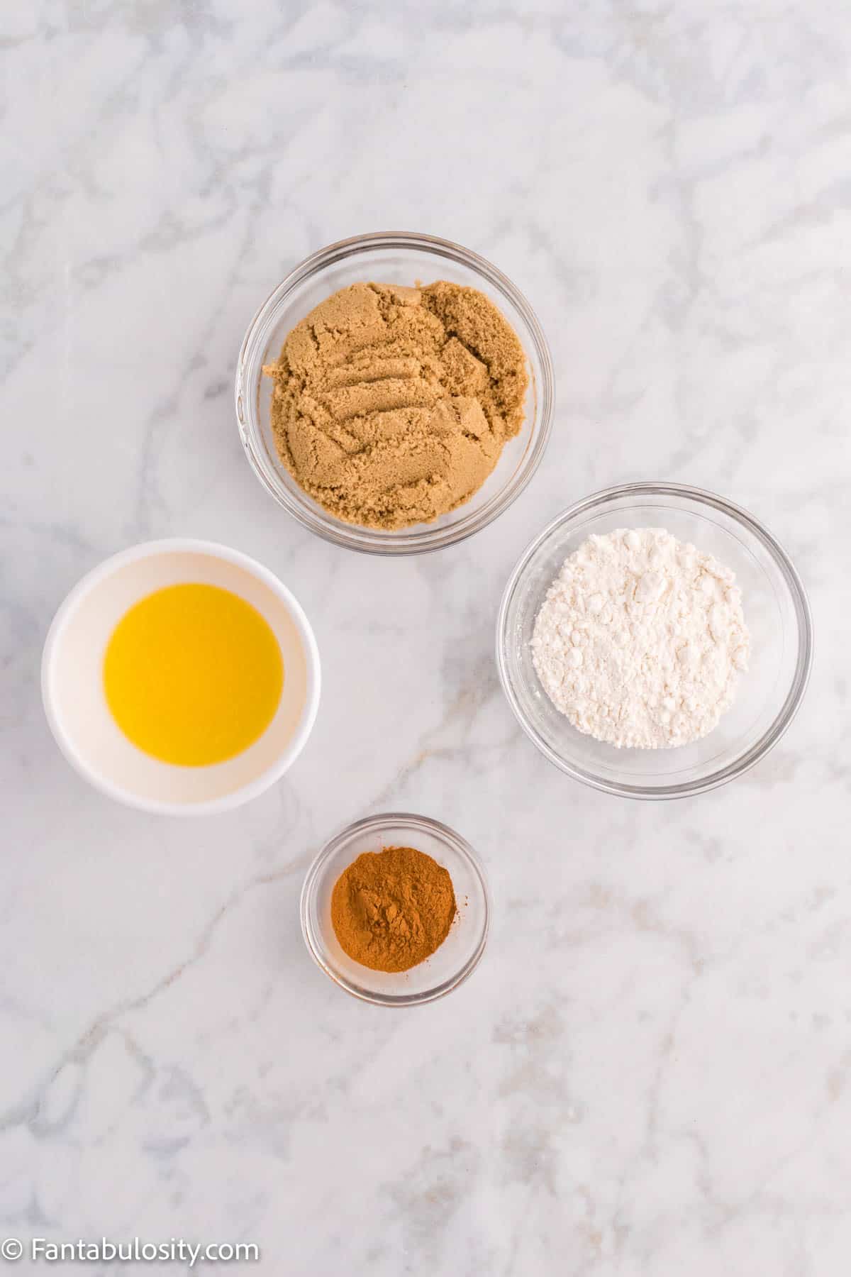 The ingredients for the cinnamon crumb topping for Cinnamon Coffee Cake are displayed in small bowls on a marble surface