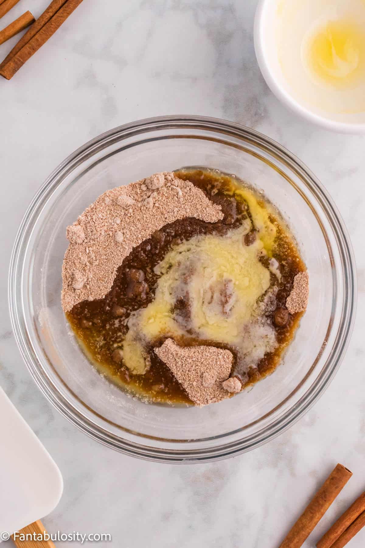 A bowl displays melted butter, brown sugar, cinnamon and flour - these ingredients will be combined to make the cinnamon crumb topping for Cinnamon Coffee Cake
