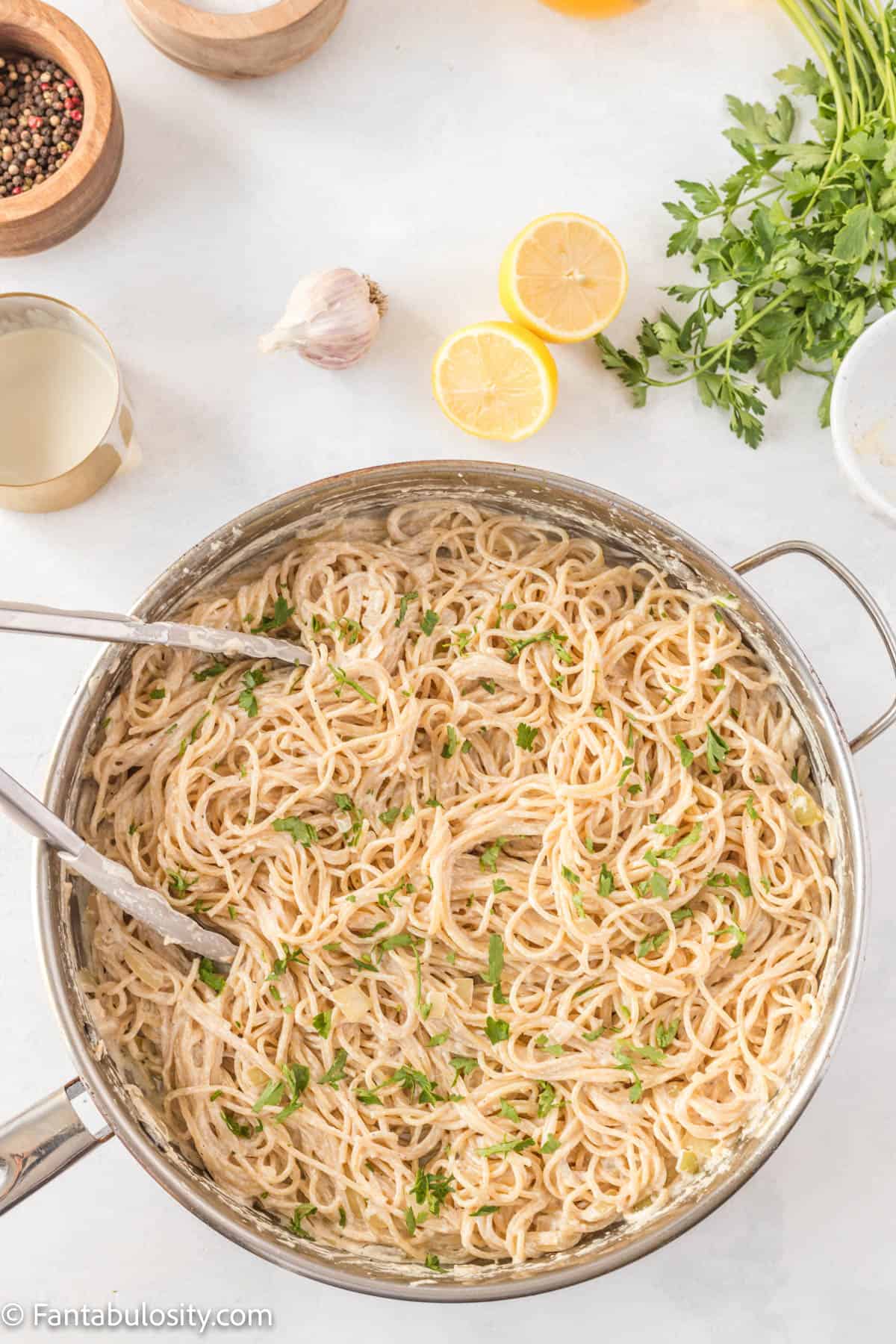 Cooked spaghetti noodles for Creamy Lemon Chicken Pasta have been stirred into the creamy sauce and then topped with parsley