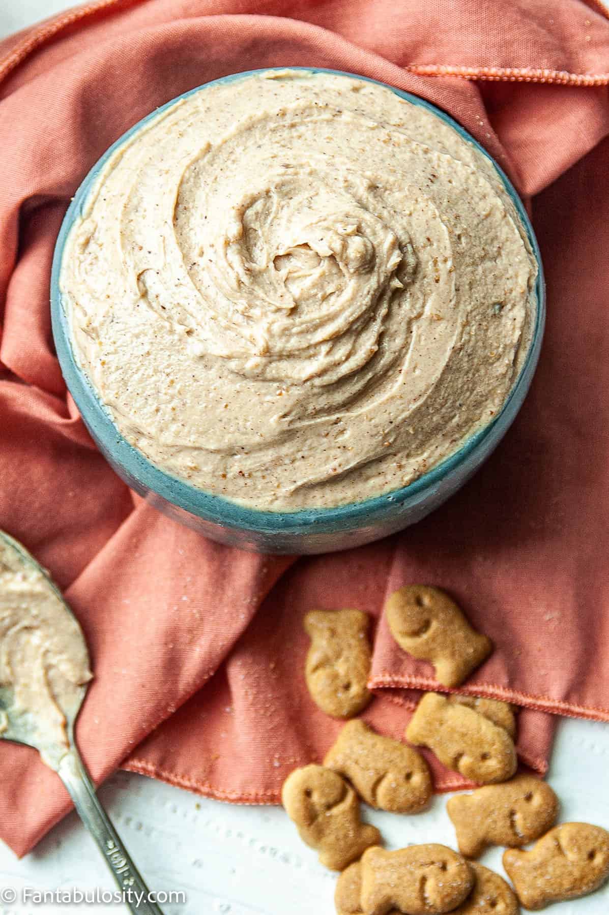 Peanut Butter Yogurt Dip is displayed in a serving bowl with a spoon to the left and graham crackers on the right