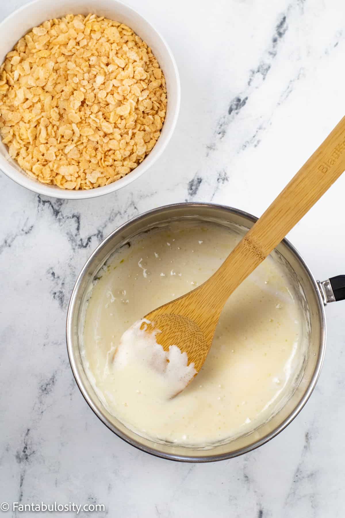 A bowl of rice krispie cereal is ready to be added to a pot of melted marshmallow and butter for the white layer of candy corn rice krispie treats